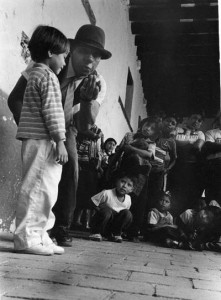 Rudi and young boy look at the red nose in Rudi's hand. celebrating our 100th project