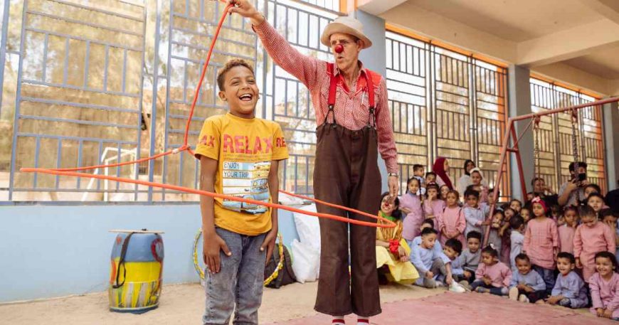 Clown spinning a lasso around a child