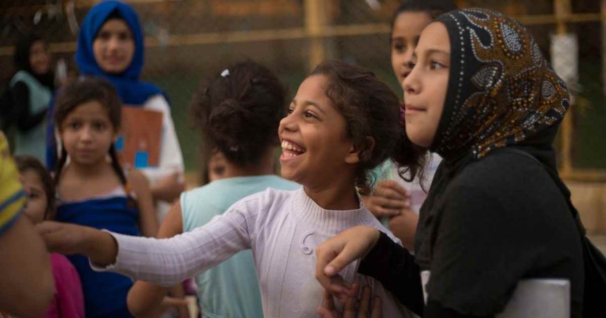 Girls in Lebanon laughing with a clown at a clown show